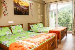 1 Schlafzimmer mit 2 Betten und einem Balkon in der Unterkunft Maple View in Udagamandalam