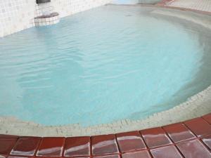 - une piscine d'eau bleue dans un bâtiment dans l'établissement Hotel Tsustujisou, à Kitami