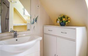 a bathroom with a sink and a vase of flowers at Holiday Home Rue Jarl Priel in Plouguiel