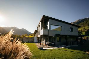 a house on a hill with mountains in the background at Landart-Appartements in Virgen