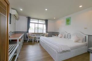 a bedroom with a bed and a desk and a table at The Mercy Hotel in Chumphon +31 photos