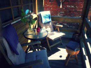 een patio met een tafel en stoelen op een veranda bij Tiny House Andersom Anders in Bad-Nieuweschans