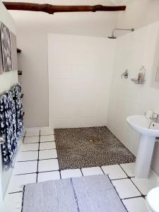 a white bathroom with a sink and a toilet at Aloe Valley Retreat in Oudtshoorn