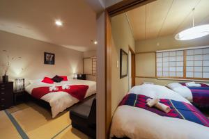 a bedroom with two beds with red and white at Luna Lodge in Hakuba