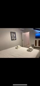 ein Schlafzimmer mit einem weißen Bett mit zwei Handtüchern darauf in der Unterkunft Tish Hotel in Jerusalem