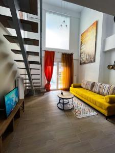 a living room with a yellow couch and a table at Escala Luxury Loft 2 in the center &Free Parking in Volos