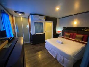Pakor Boutique Resort في فانجنجا: غرفة نوم بسرير ومكتب مع تلفزيون