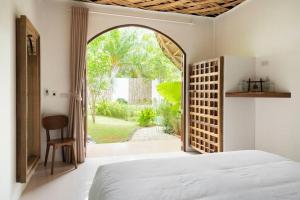 a bedroom with an open door to a garden at Aloe Ecological Boutique Villa 2 in Ao Nam Mao