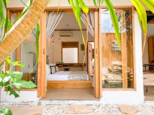 a bedroom in a villa with a bed in a window at Villa Casa Koko in Gili Air