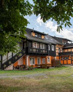 ein Haus mit einem schwarzen und orangefarbenen Gebäude in der Unterkunft Ferienhaus Ostrauer Hof in Bad Schandau