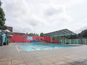 an empty swimming pool with a red and green building at SPOT ON 91860 Amazon Homestay Syariah 2 in Sukabumi