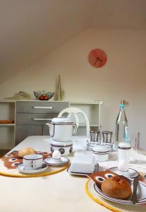 a table with plates and cups and dishes on it at Ferienwohnung Sternenkieker in Krummhörn