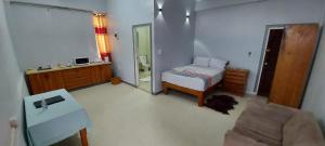 a bedroom with a bed and a chair and a mirror at Marine Apartments in Honiara