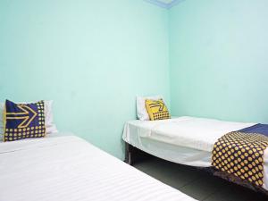 Katil atau katil-katil dalam bilik di SPOT ON 91860 Amazon Homestay Syariah 2