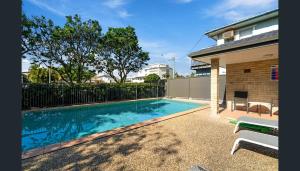 a swimming pool in the backyard of a house at sunrise on the beach in Gold Coast