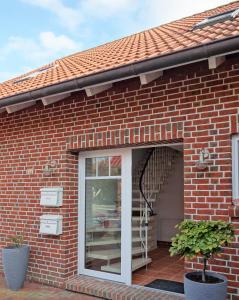 ein Backsteinhaus mit einem Fenster und einer Wendeltreppe in der Unterkunft Ferienwohnung Sternenkieker in Krummhörn