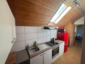 a kitchen with a sink and a red refrigerator at obermaubach-am see Apartments in Kreuzau