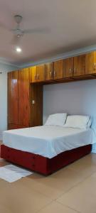 um quarto com uma cama grande e armários de madeira em Marine Apartments em Honiara