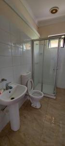 uma casa de banho com um lavatório, um WC e um chuveiro em Marine Apartments em Honiara