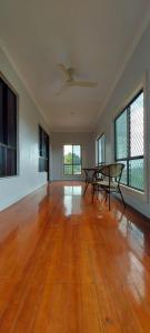 an empty living room with a ceiling fan and a table at Marine Apartments in Honiara