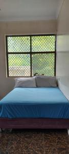 a bed in a room with a large window at Marine Apartments in Honiara