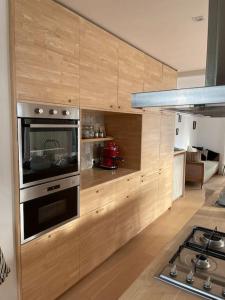 a kitchen with wooden cabinets and a stove top oven at Zeehuis in Koksijde