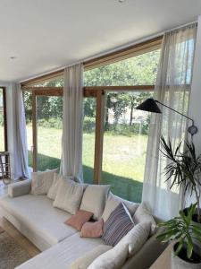 a living room with a white couch in front of a window at Zeehuis in Koksijde