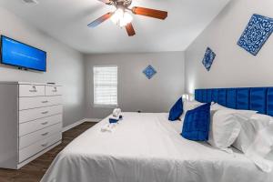 a bedroom with a white bed with a ceiling fan at Family Friendly 2bdrm-Walk To At&t/Cowboys Stadium in Arlington
