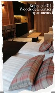 a bed with two pillows on it in a room at Kopaonik011 Konaci&WoodSide Apartments in Kopaonik