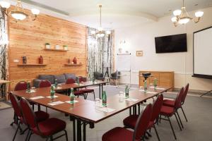 a conference room with tables and chairs and a screen at Hotel San Marco in Lannach