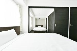 a bedroom with a large white bed and a window at サンコート本通ガーデンヒルズ in Tsukisappu