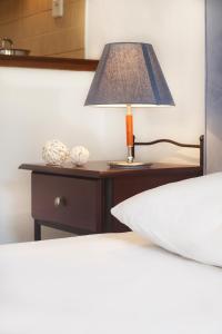 a lamp on a night stand next to a bed at Maltinas House in Mola Kalyva