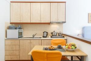 a kitchen with a table with a bowl of fruit on it at Maltinas House in Mola Kalyva