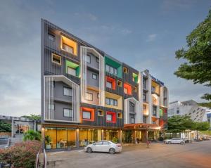a building with colorful windows and a car parked in front at Prime Square Hotel in Chiang Mai