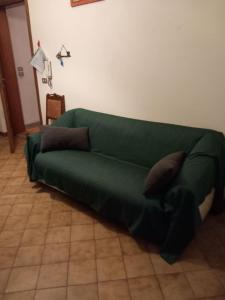 um sofá verde sentado numa sala de estar em LA CASA DEI CILIEGI em Brossasco