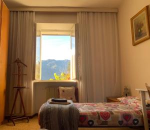 een slaapkamer met een bed en een raam bij B&B Casa d'Arte in Levico Terme
