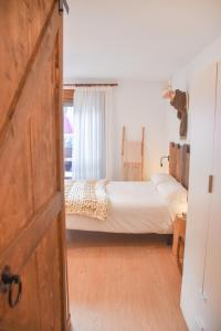 um quarto com uma cama com lençóis brancos e uma janela em Fabuleux studio, belle décoration et excellent emplacement em Pas de la Casa