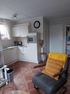 a kitchen with a couch and a clock on the wall at Siësta in Westkapelle