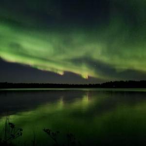 a group of green clouds over a body of water at Revontulen Tupa in Kaamanen