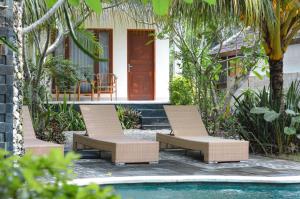 - deux chaises et une piscine en face d'une maison dans l'établissement Tarzan Marriott On Penida, à Nusa Penida