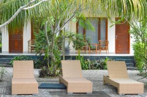 un groupe de chaises assises devant une maison dans l'établissement Tarzan Marriott On Penida, à Nusa Penida