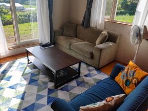 a living room with a couch and a coffee table at Guest House ONLY ONE in Niseko