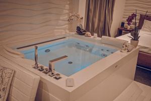 uma banheira de hidromassagem num quarto de hotel em F53 Kevin's Charming Houses em Alghero