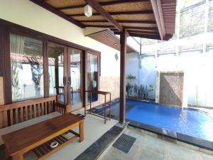 Casa con piscina y banco de madera en Villa Sahabat, en Gili Trawangan