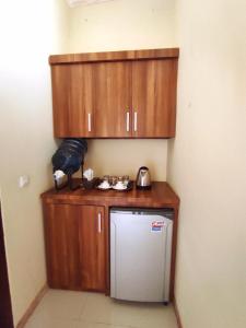 a small kitchen with wooden cabinets and a refrigerator at Villa Sahabat in Gili Trawangan