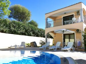 eine Villa mit einem Pool vor einem Haus in der Unterkunft Residence con piscina a Badesi, appartamenti con WIFI e A.C in Badesi