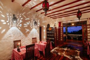um restaurante com mesas e cadeiras num quarto em The Litchi Tree Amber Mountain Boutique Hotel em Ambohitra