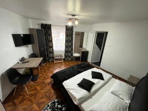 a bedroom with a bed and a desk and a table at Dry Valley in Câmpulung Moldovenesc