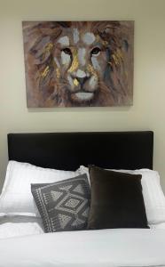 uma pintura de uma cabeça de leão está acima de uma cama em The Yellow Door em Castleisland