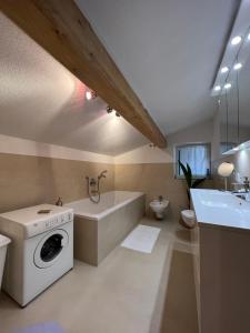 W łazience znajduje się pralka i wanna. w obiekcie Liboria: lovely,cosy apartment. 2 min skilift walk w mieście Campitello di Fassa